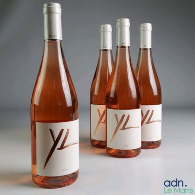 Quatre bouteilles de vin rosé sont alignées sur une table