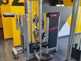 une salle de sport équipée de deux appareils et d'un mur jaune