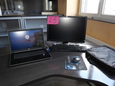 a laptop computer sitting on top of a desk next to a computer monitor