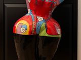 a colorful sculpture of a woman on a black stand
