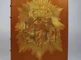 an orange book with a gold design on the cover