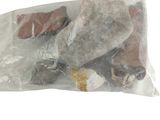 un sac rempli de cailloux et de pierres posé sur une surface blanche