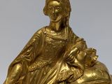 an image of a gold clock with a statue of a woman on top of it