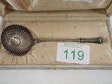 a silver spoon in a box with a price tag on it