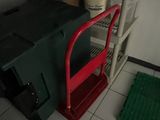 a red cart sitting next to a green cart in a room