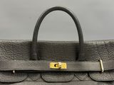a black leather handbag with gold hardware on the handle