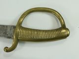 a close up of a sword with a handle on a white surface