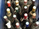 many bottles of wine in a blue basket on the floor