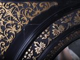 a close up of a black and gold clock with gold designs on it