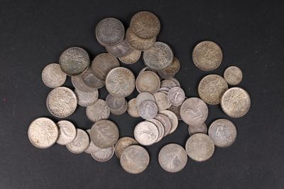 un tas de vieilles pièces d'argent posées sur une surface noire