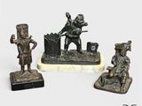 trois figurines en bronze représentant un homme et une femme assis sur un banc