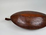 carvings on a wooden bowl on a white surface
