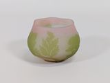 un vase en verre rose et vert orné de feuilles