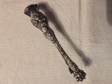 une cuillère en argent ornée d'un oiseau, posée sur une table