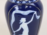 un vase bleu avec l'image d'une femme dessus