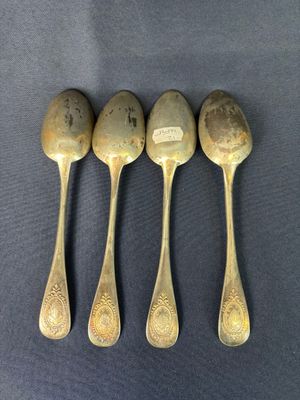 four spoons are lined up in a row on a table