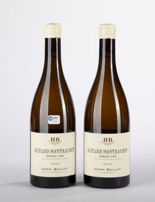 deux bouteilles de vin posées l'une à côté de l'autre sur une surface blanche