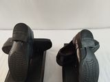 pair of men ' s black slippers on display on a white surface