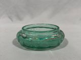 an image of a green glass candle holder sitting on a white surface