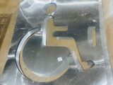 a metal sign that has a handicap sign on it