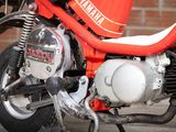 a red motorcycle parked in front of a brick wall