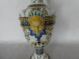 a vase with a face painted on it sitting on a table
