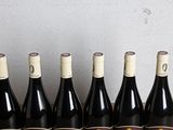 six bottles of wine are lined up in a row on a table