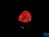 a red diamond on a black surface in the dark