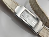 une image représentant une montre-bracelet avec un bracelet en cuir posée sur une surface blanche