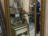 a mirror that is sitting on the floor next to some pictures