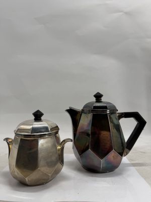 two silver teapots and a silver teapot sitting on a table