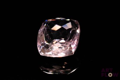 a close up of a pink diamond on a black surface