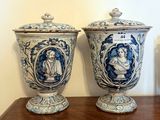 two vases sitting on a wooden table with blue and white designs on them