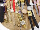 many different types of watches displayed on a wooden tray
