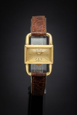 a close up of a watch on a black surface with a black background