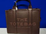 a brown tote bag sitting on top of a white table