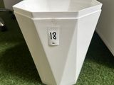 a white planter sitting on the grass in the office