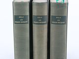 trois livres sont empilés sur une surface blanche