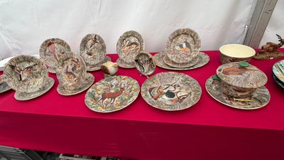 plusieurs assiettes et tasses sur une table avec une nappe rouge