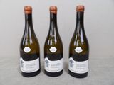 three bottles of wine are lined up on a table