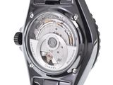 the back of a watch with a black band and a silver face
