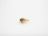 a close up of a gold ring with a red stone