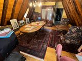 a living room with a couch, chair, table, and pictures on the wall