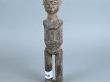 une vieille statue en bois d'un homme avec un chapeau sur la tête