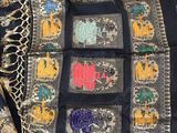 a close up of a black and gold sari with elephants and elephants on it