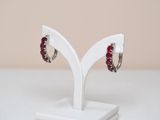 pair of red crystal hoop earrings on a white display stand
