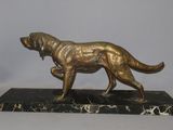 bronze statue of a dog on a marble base on a white background