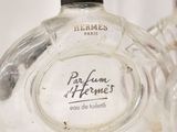 two perfume bottles sitting next to each other on a white surface