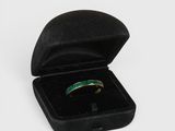 a close up of a ring in a black box on a white surface