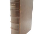 un vieux livre posé sur une table blanche à côté d'un mur blanc